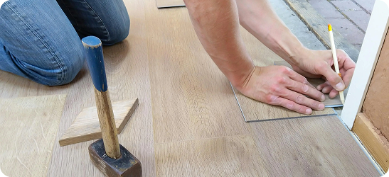 Carpenter measuring wooden floor
